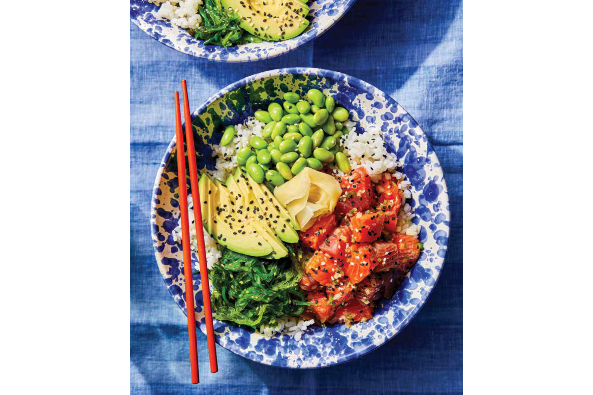 A bowl of poke with chopsticks resting on top.