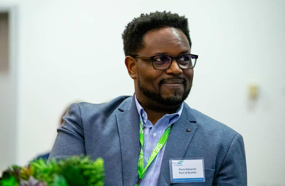 Paris Edwards swears a suit and glasses and smiles
