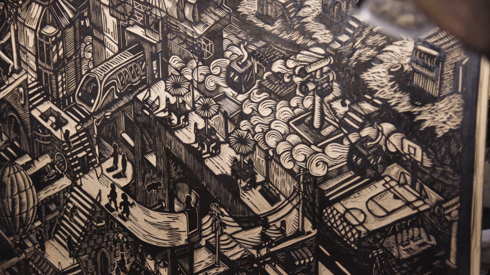 A close-up of a print woodblock carved with trains, gondolas, clouds and stairs.