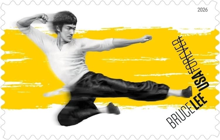 Image of a postage stamp featuring martial artist Bruce Lee leaping into a flying kick in black-and-white against a yellow background.