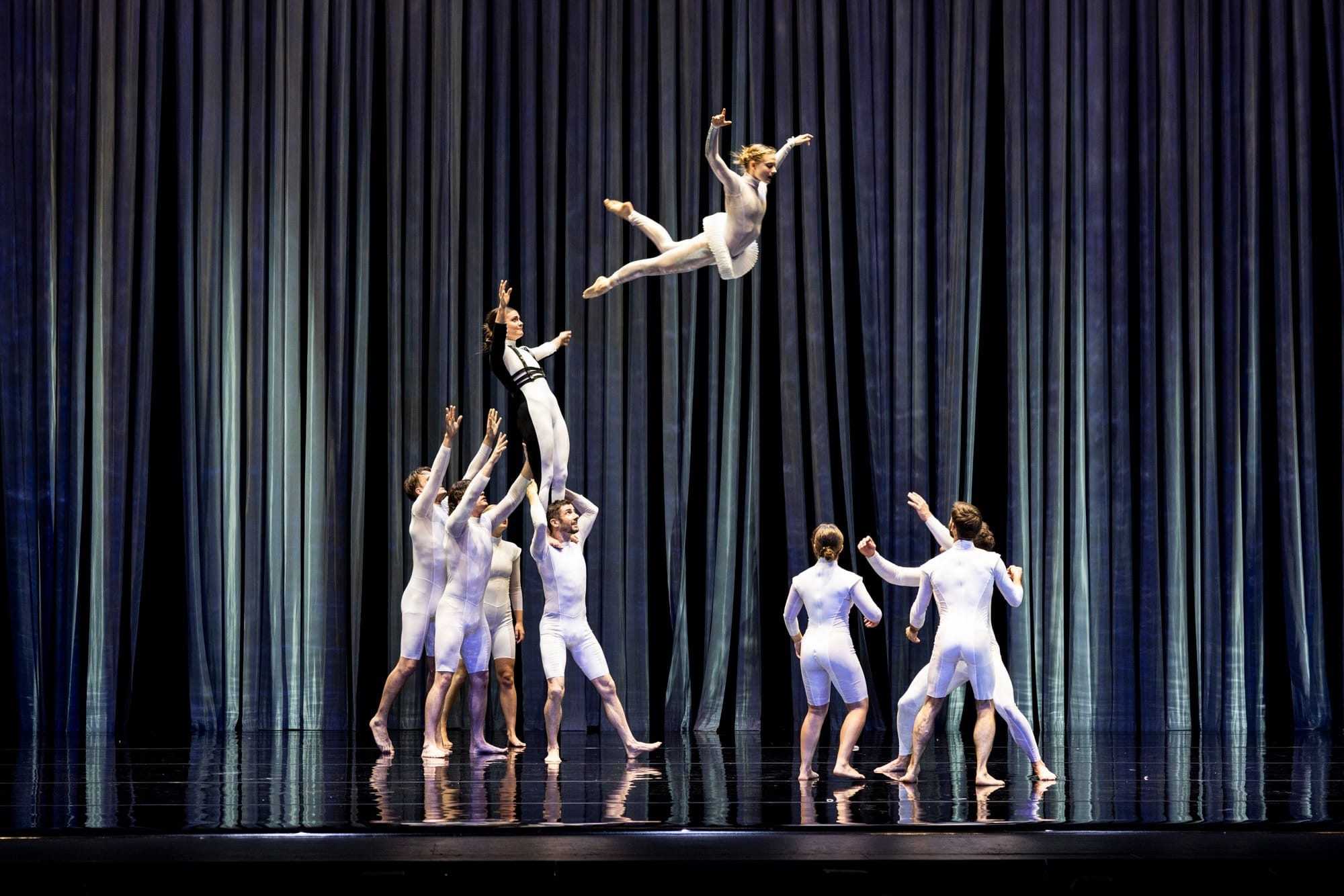 Dancers toss a person high into the air