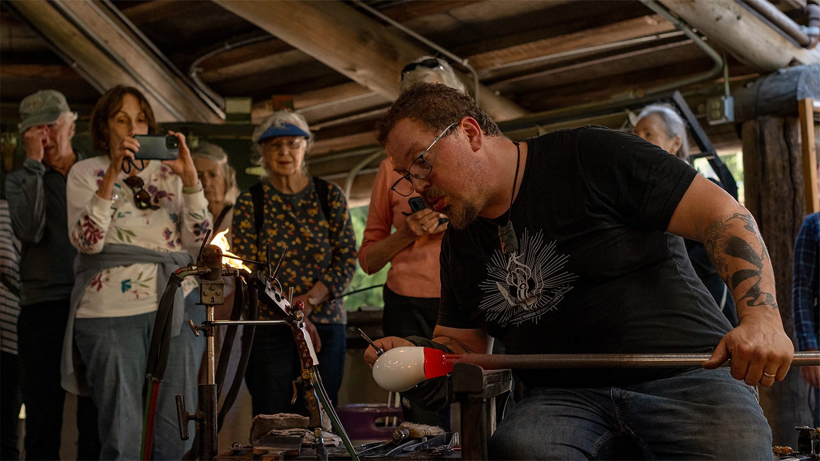A glassblower works in front of an audience 