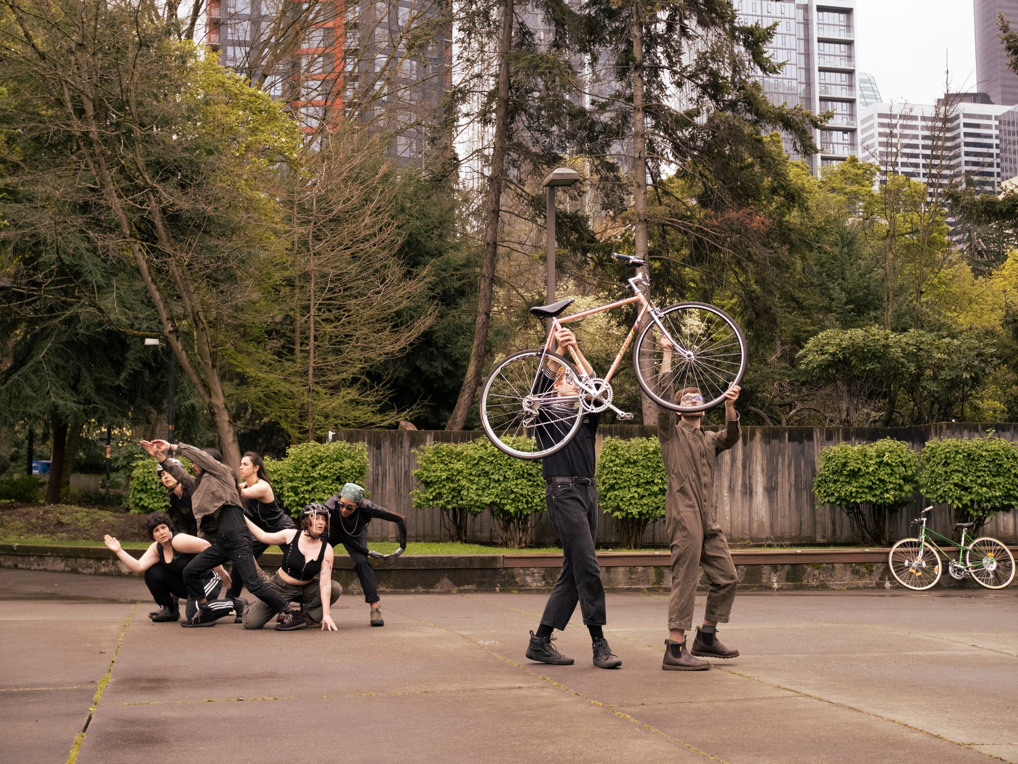 People dance, two of them hoisting bikes over their heads
