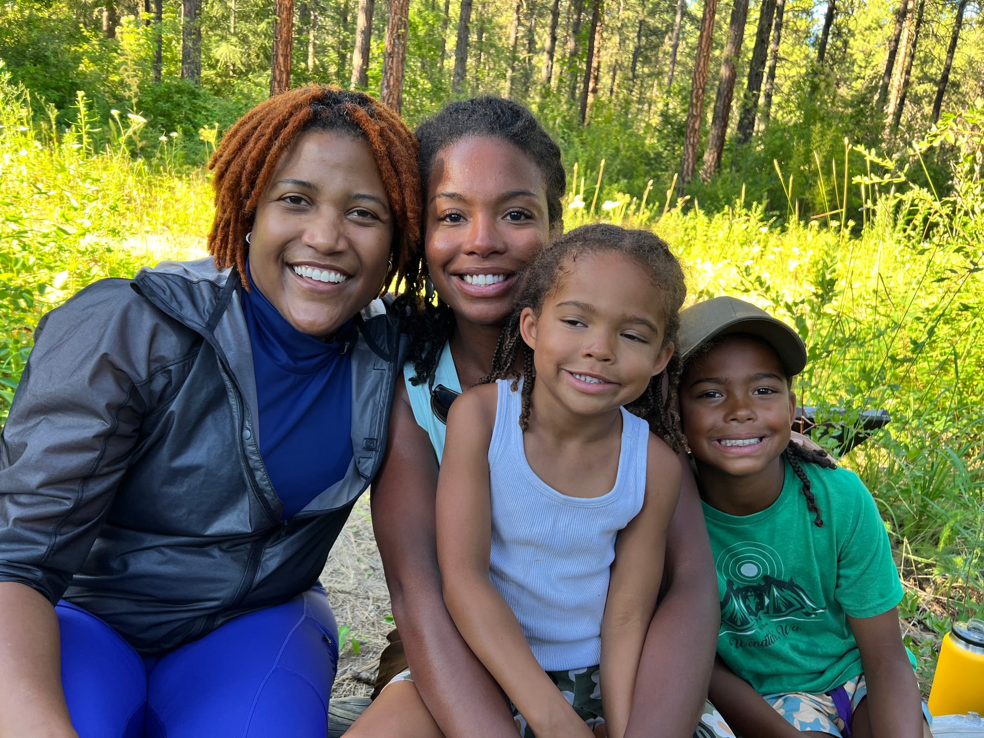 Four people sit together in a forest