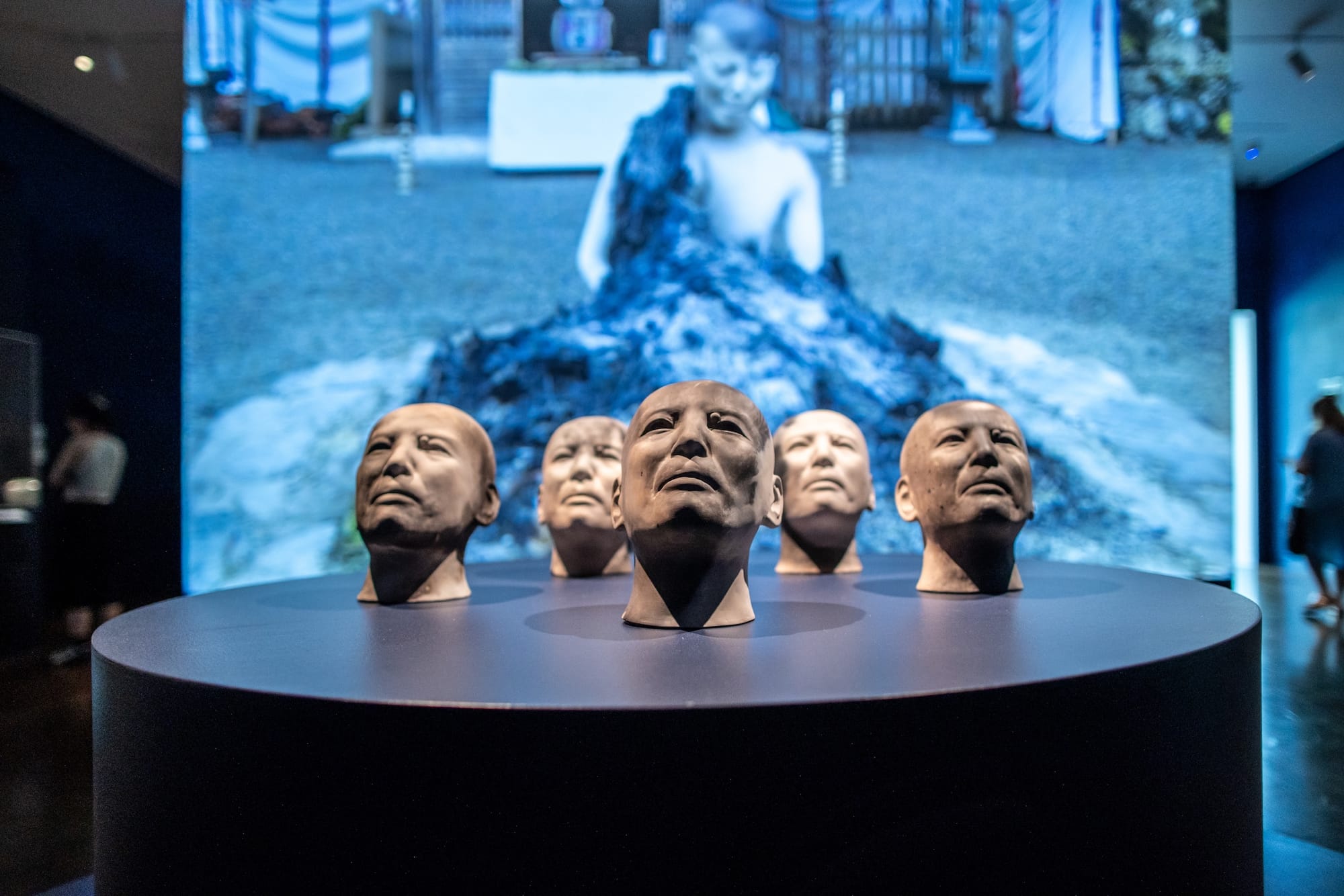 Ceramic head sculptures against a film backdrop