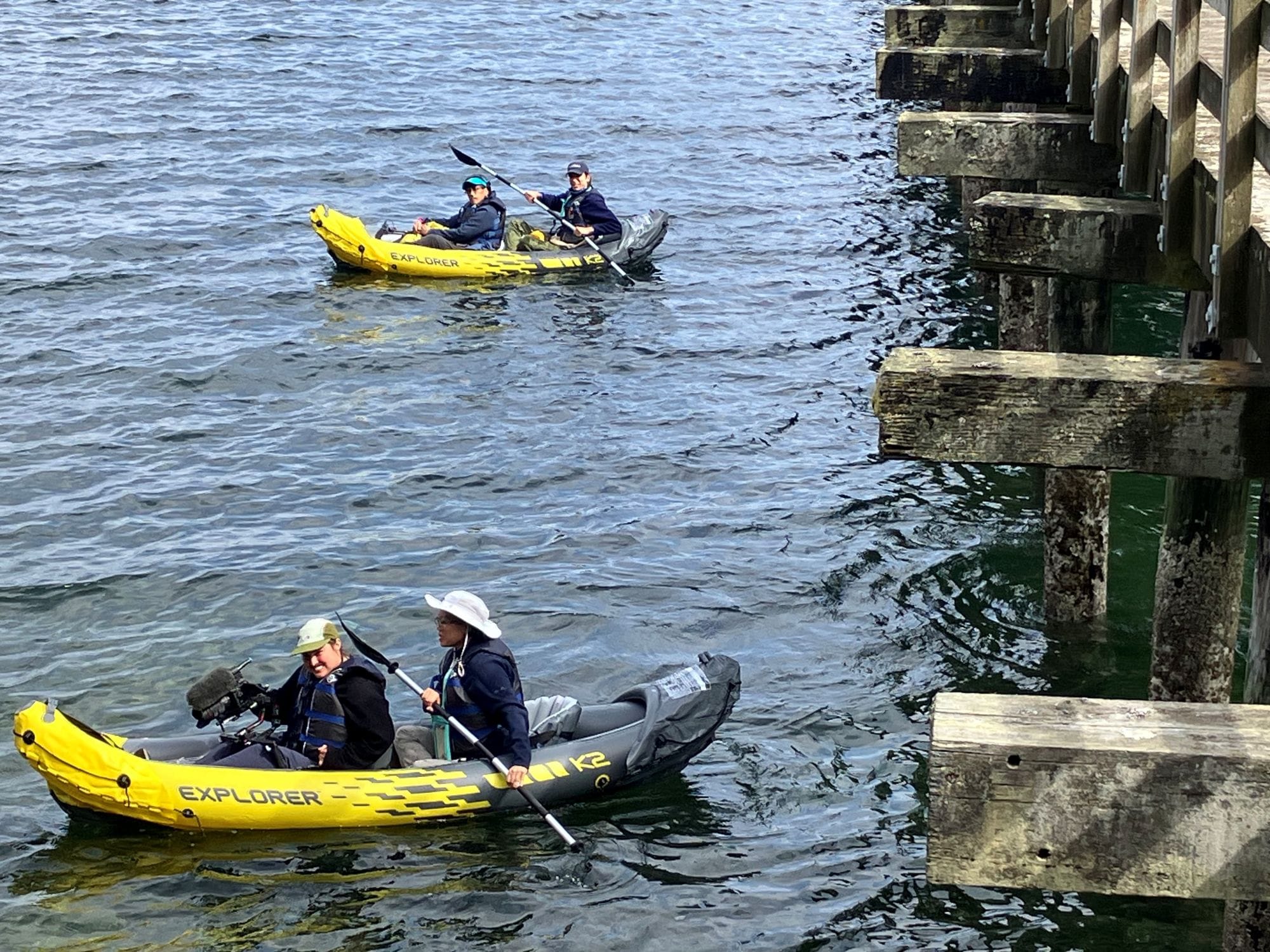 People with film equipment in kayaks