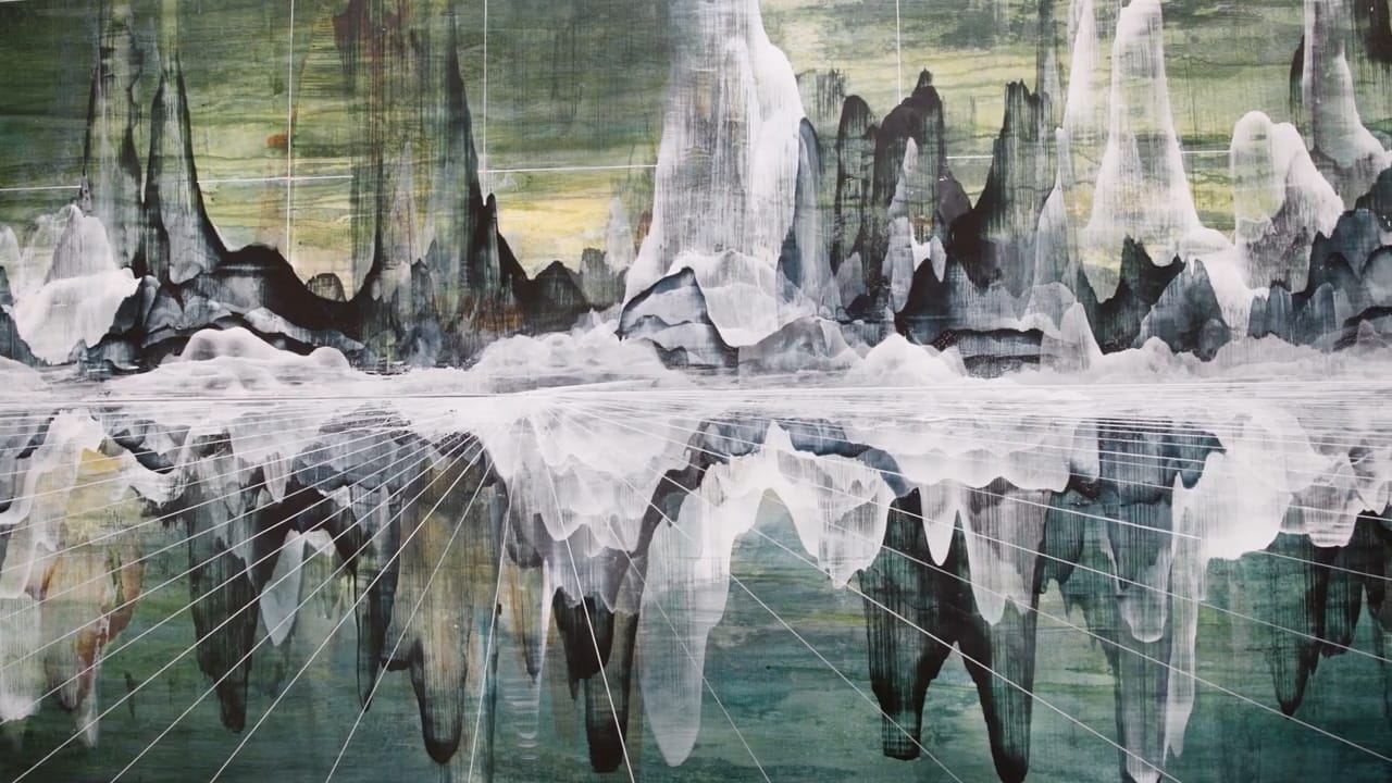 Close-up of an abstract painting featuring what look like white and gray mountains reflected in water below