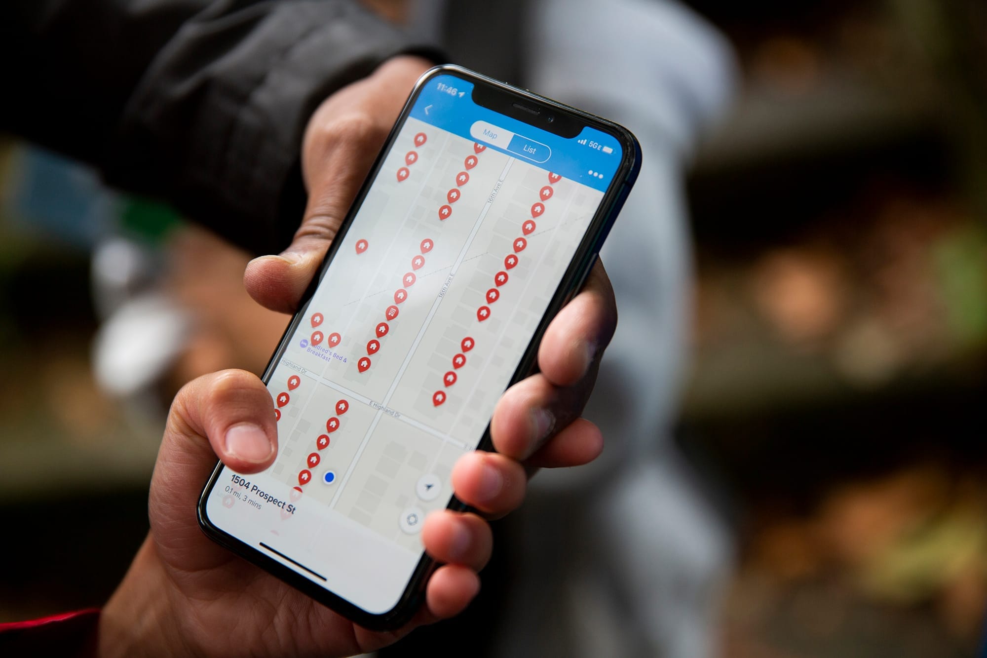 A volunteer holds a smart phone showing a map of households visited by the campaign.
