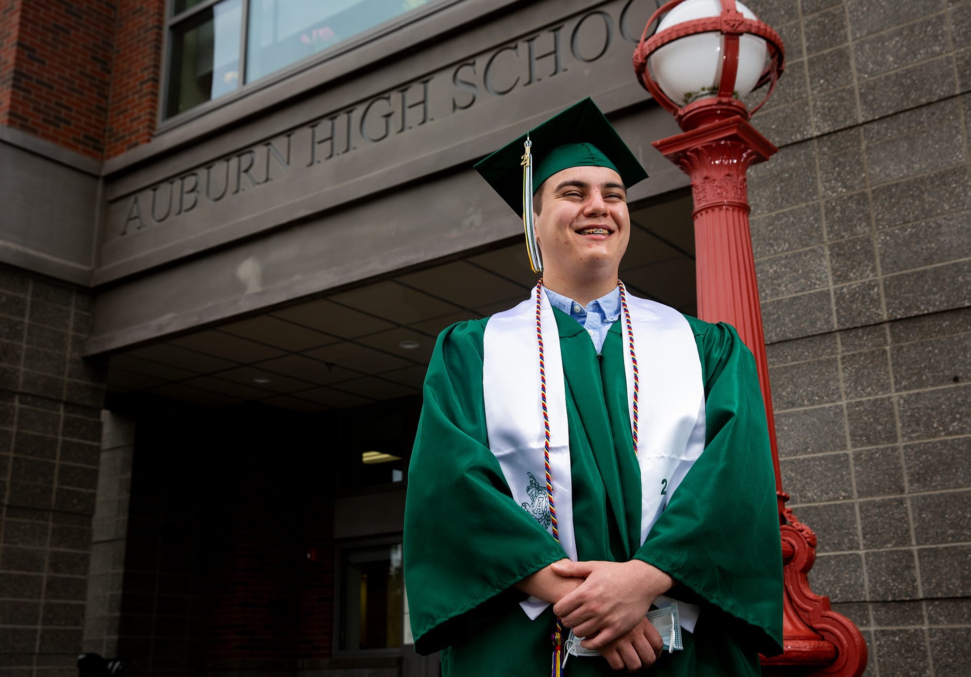 Senior Jacob Hutchens, 18, holds a mask while posing for a portrait