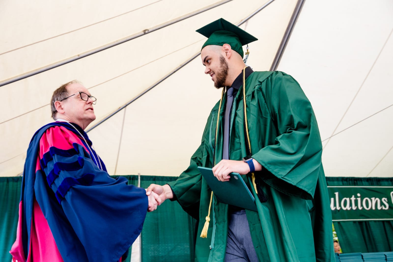 Evergreen President George Bridges hands out a diploma at the 2018 commencement ceremony