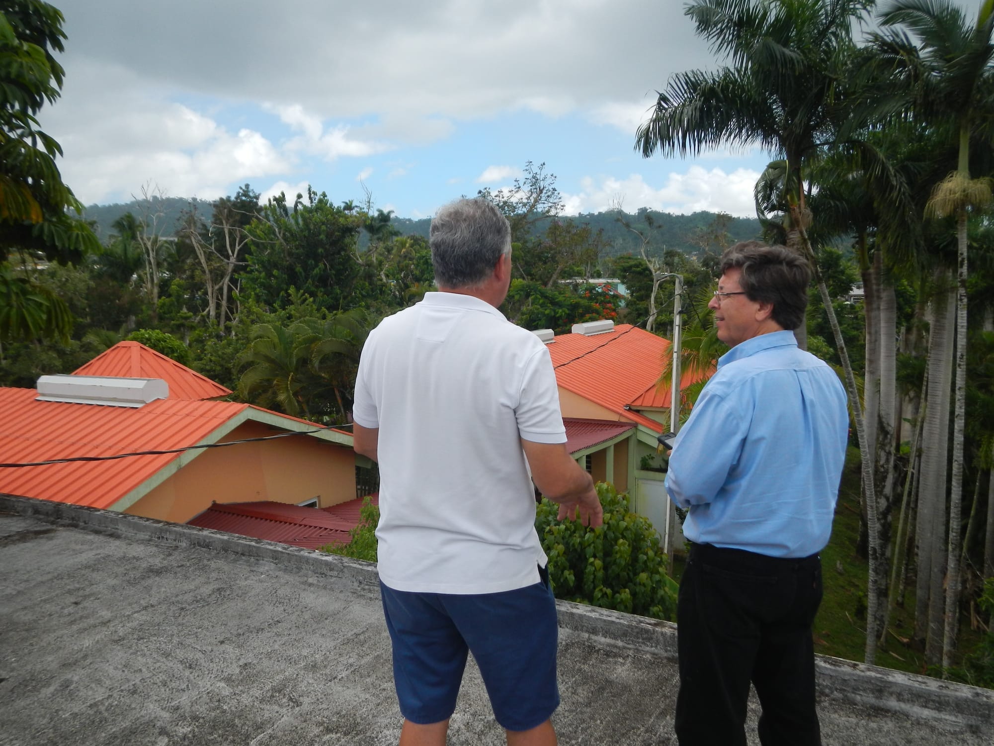 Two people discuss the solar panels on the roof of the school.