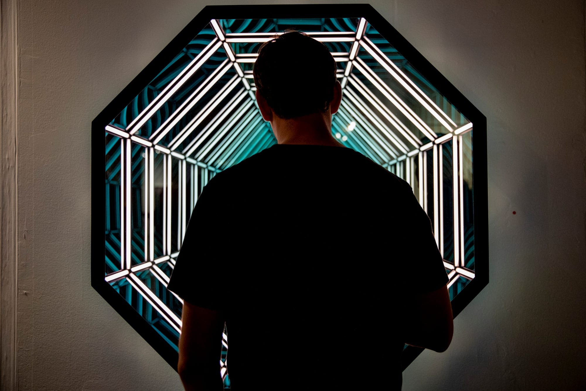 An attendee looks at a piece from Melissa Morgan Fine Art during the Seattle Art Fair at CenturyLink Field Event Center on Aug. 1, 2019. The fair goes Friday through Sunday. (Photo by Dorothy Edwards/Crosscut)