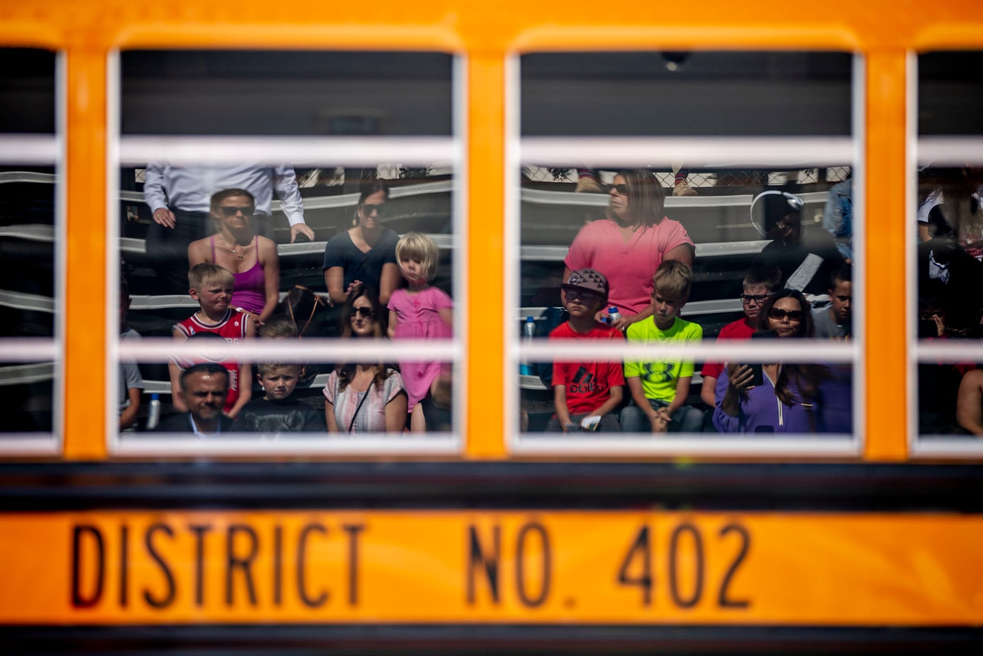 Attendees listen to speakers in front of the first electric school bus in Washington state during an event with Governor Jay Inslee at Franklin Pierce High School in Tacoma on June 17, 2019. (Photo by Dorothy Edwards/Crosscut)