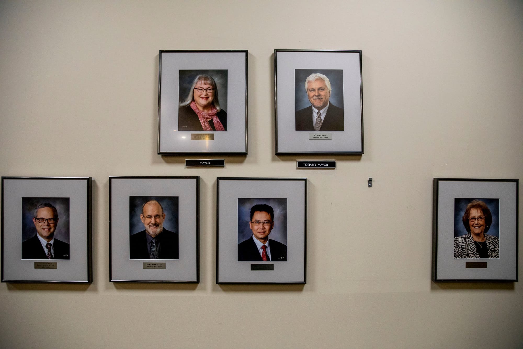Photos of each SeaTac councilmember on a wall and a blank space where the new councilmember's headshot will be