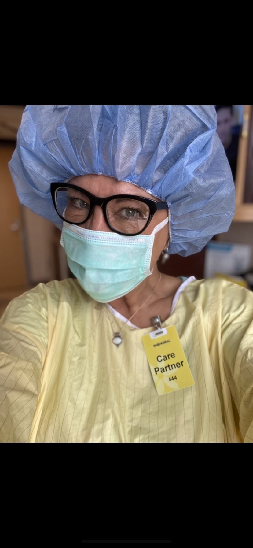 Gina Wassemiller in a hospital gown wearing a badge that reads "care partner"
