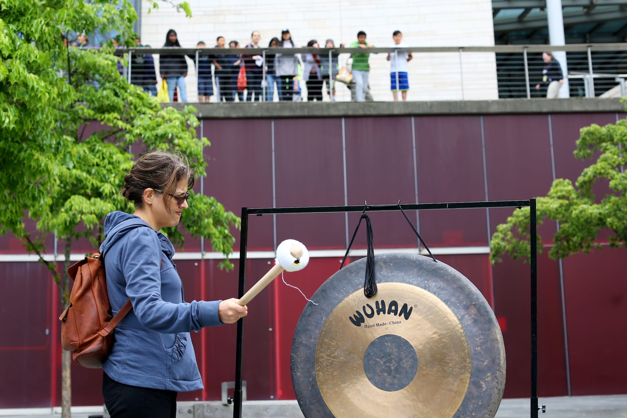A woman strikes the gong during the event "Unacceptable: A Day of Mourning"