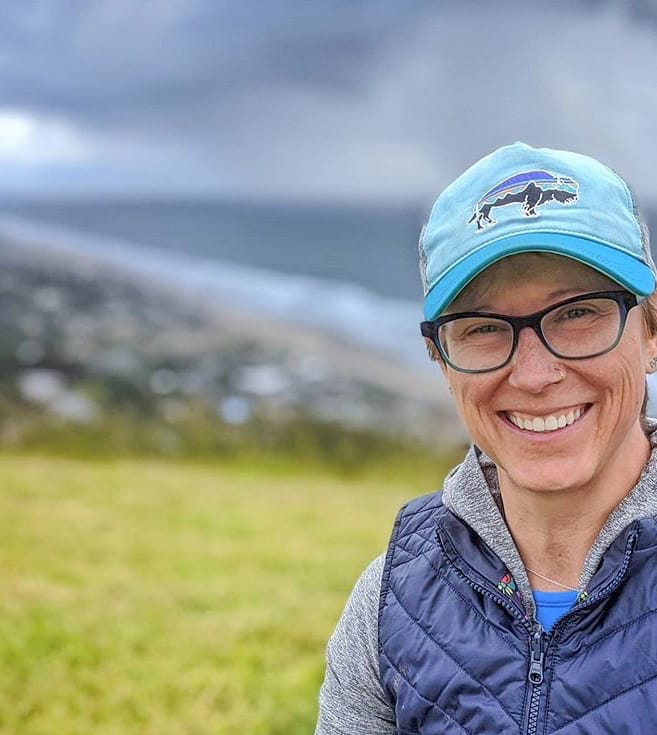 A woman in a hat faces the camera