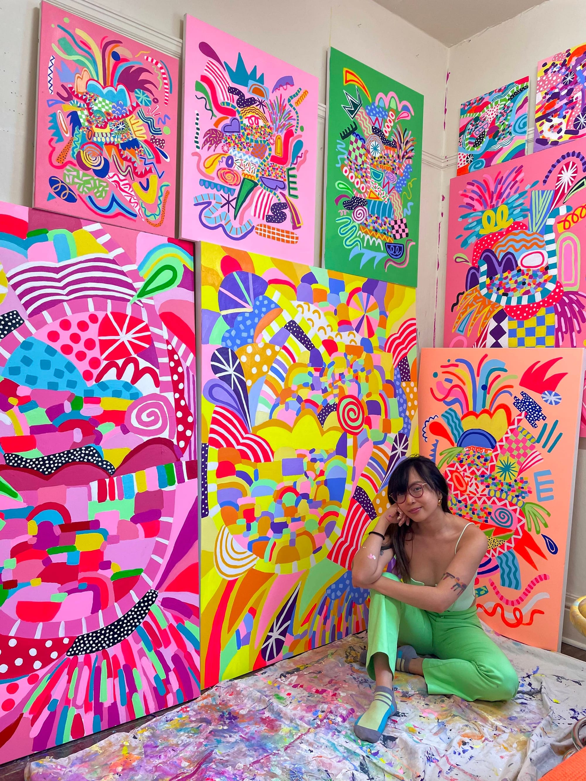 Person in front of six colorful paintings