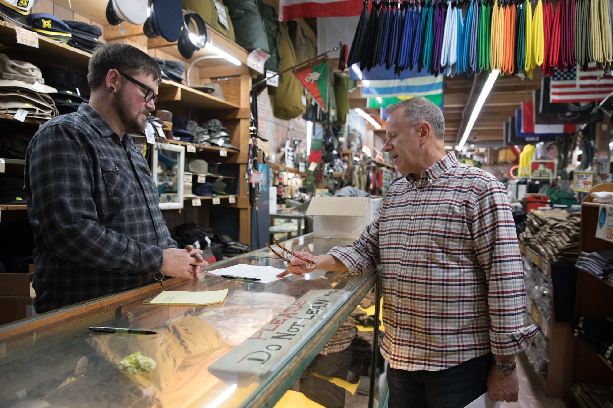 A man walks out the door of the Federal Army & Navy Surplus store in Seattle's Belltown neighborhood, April 19.