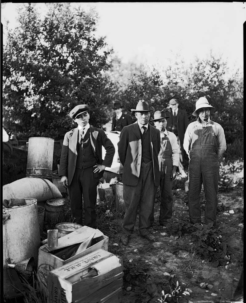 people hanging around after a raid on a distillery