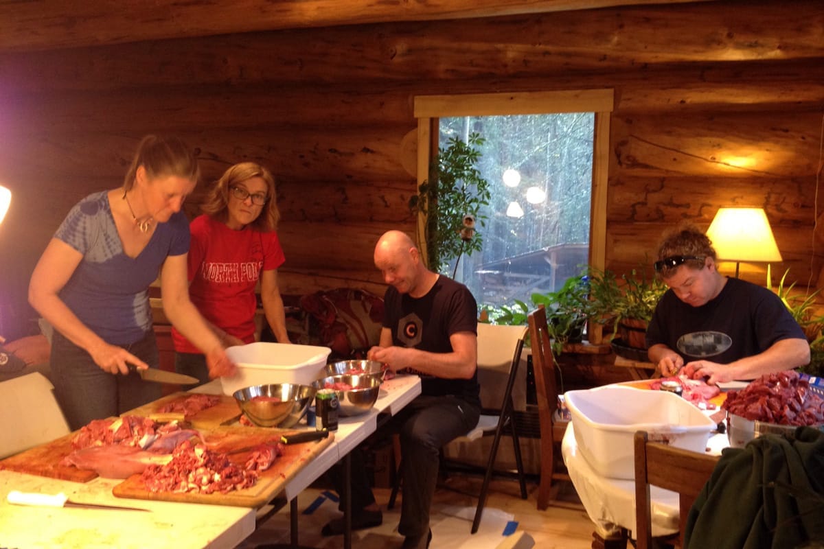 family cutting raw meat