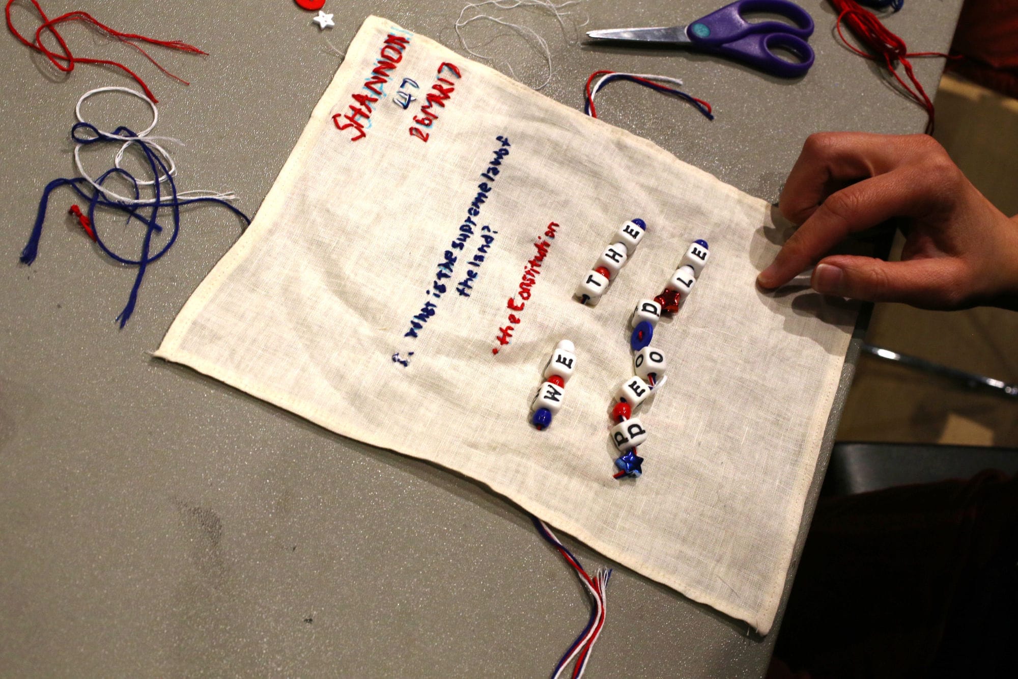 Embroidery of question number one: "What is the Supreme Law of the land?" and answer: "The Constitution"