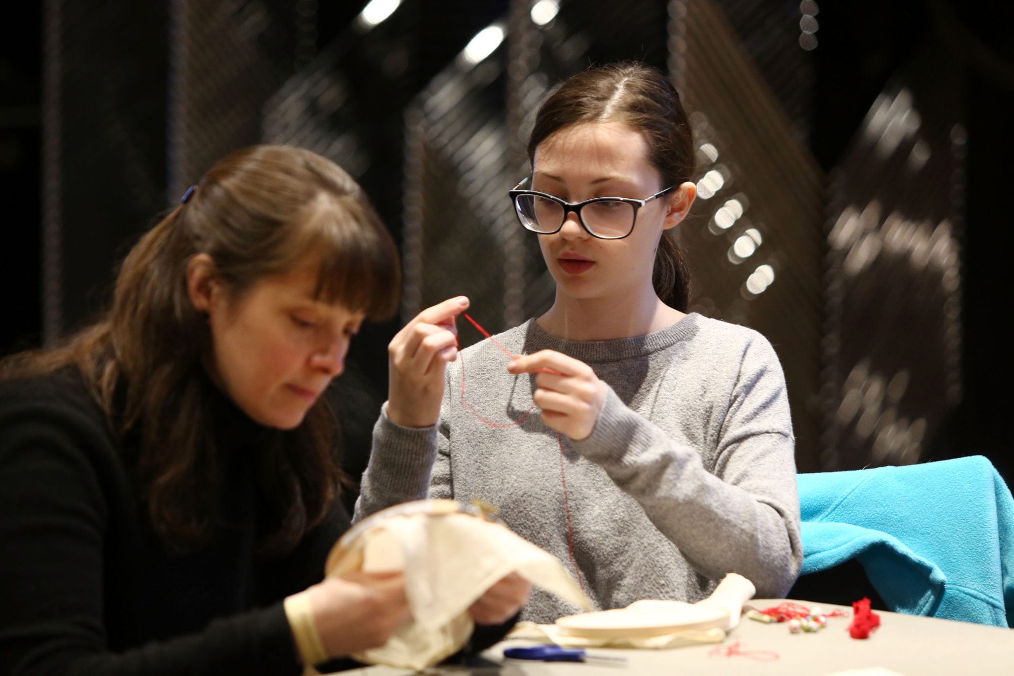 Two women participate in an embroidery workshop