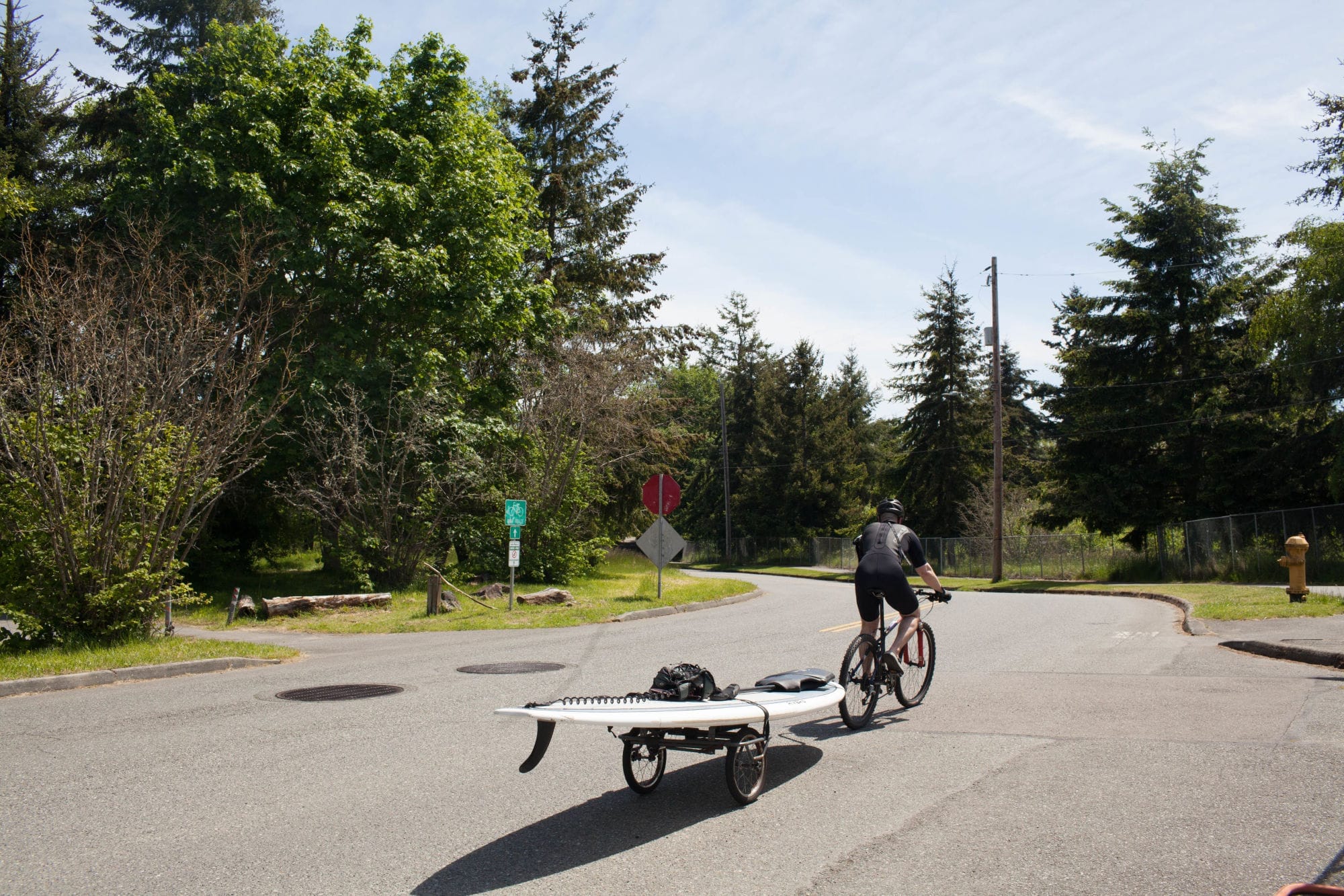Man on a bicycle pulling his paddle board
