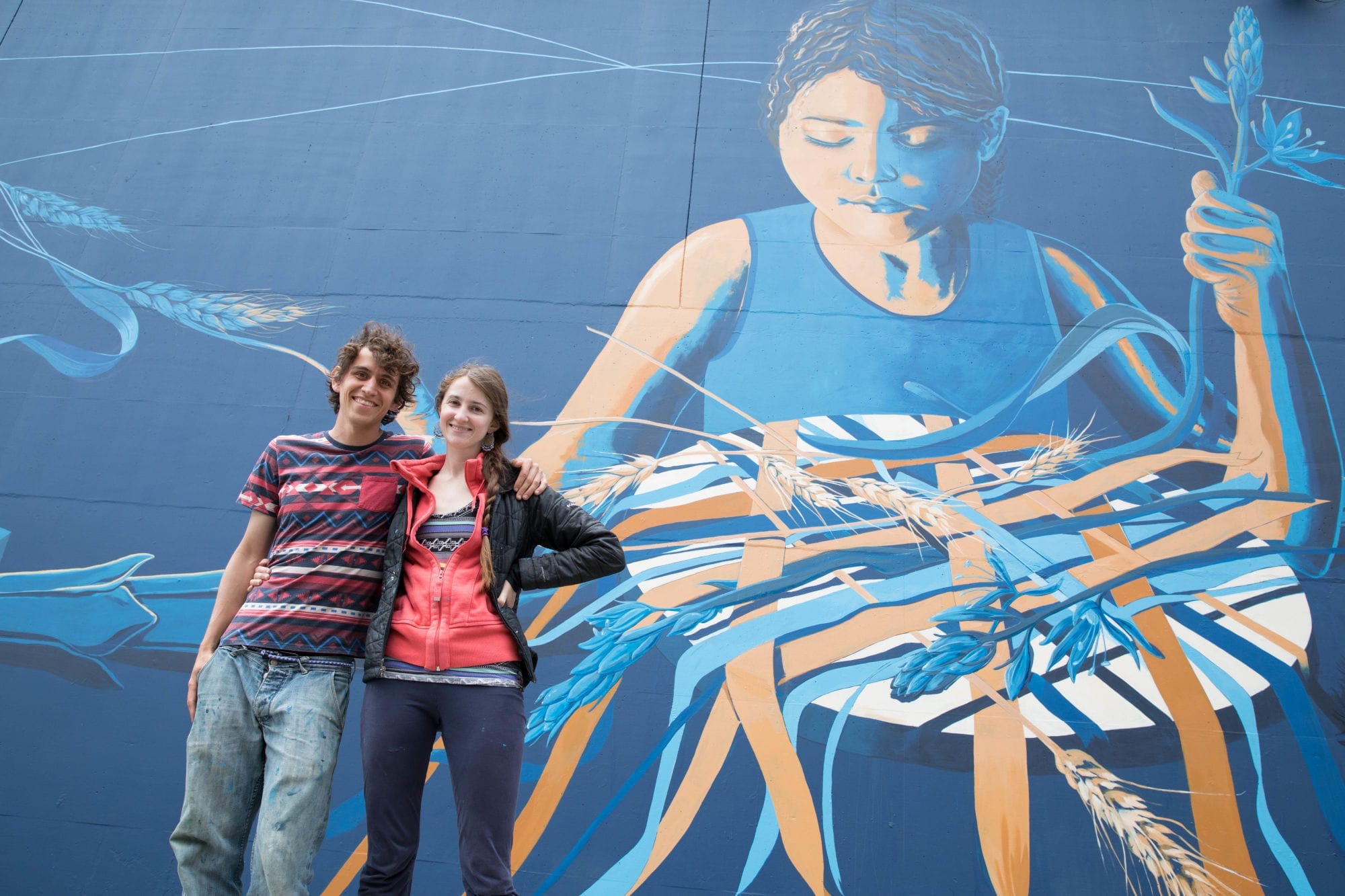 Collaborators Esteban Camacho Steffensen and Jessilyn Brinkerhoff stand in front of the mural