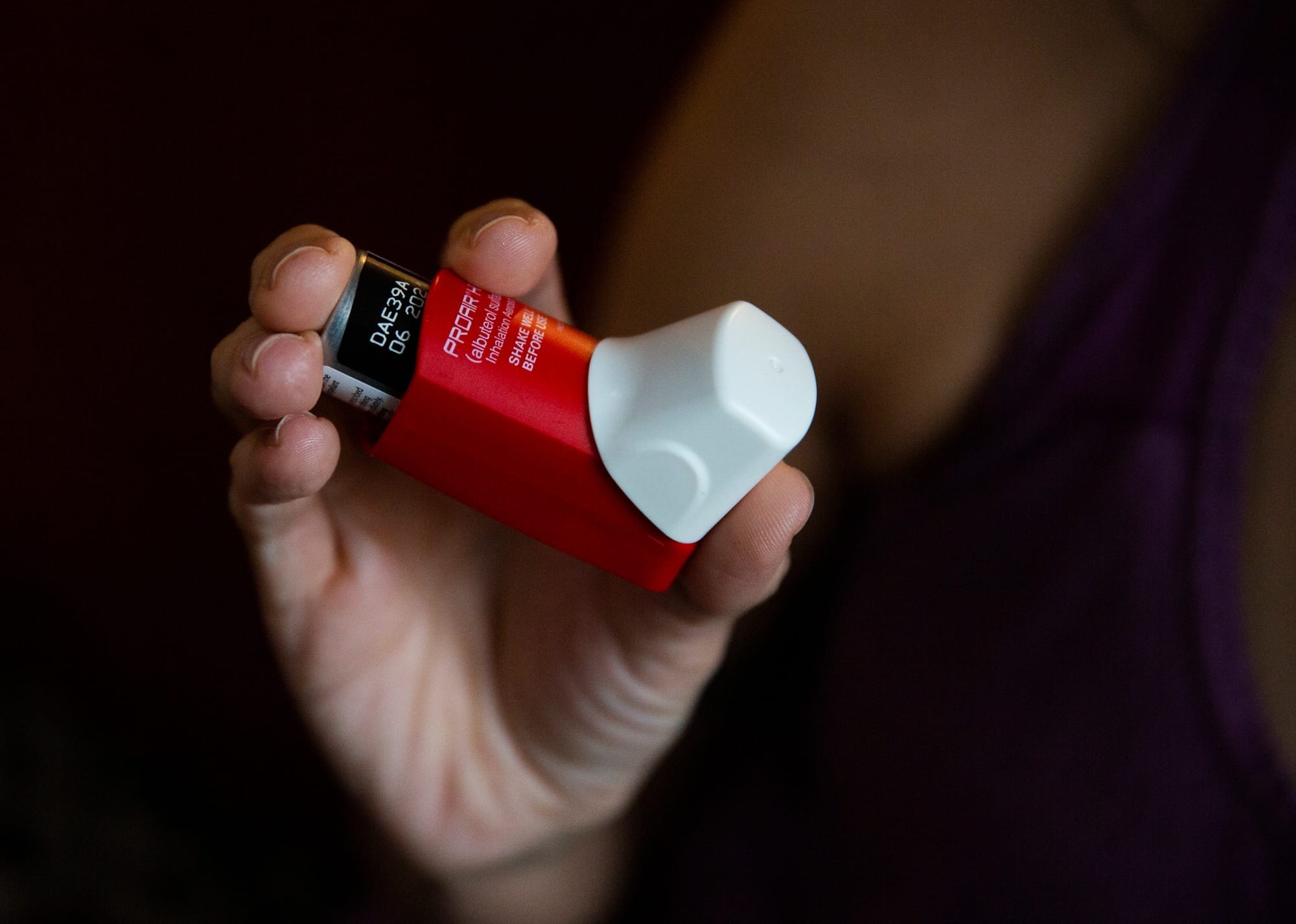 Melissa holds an inhaler