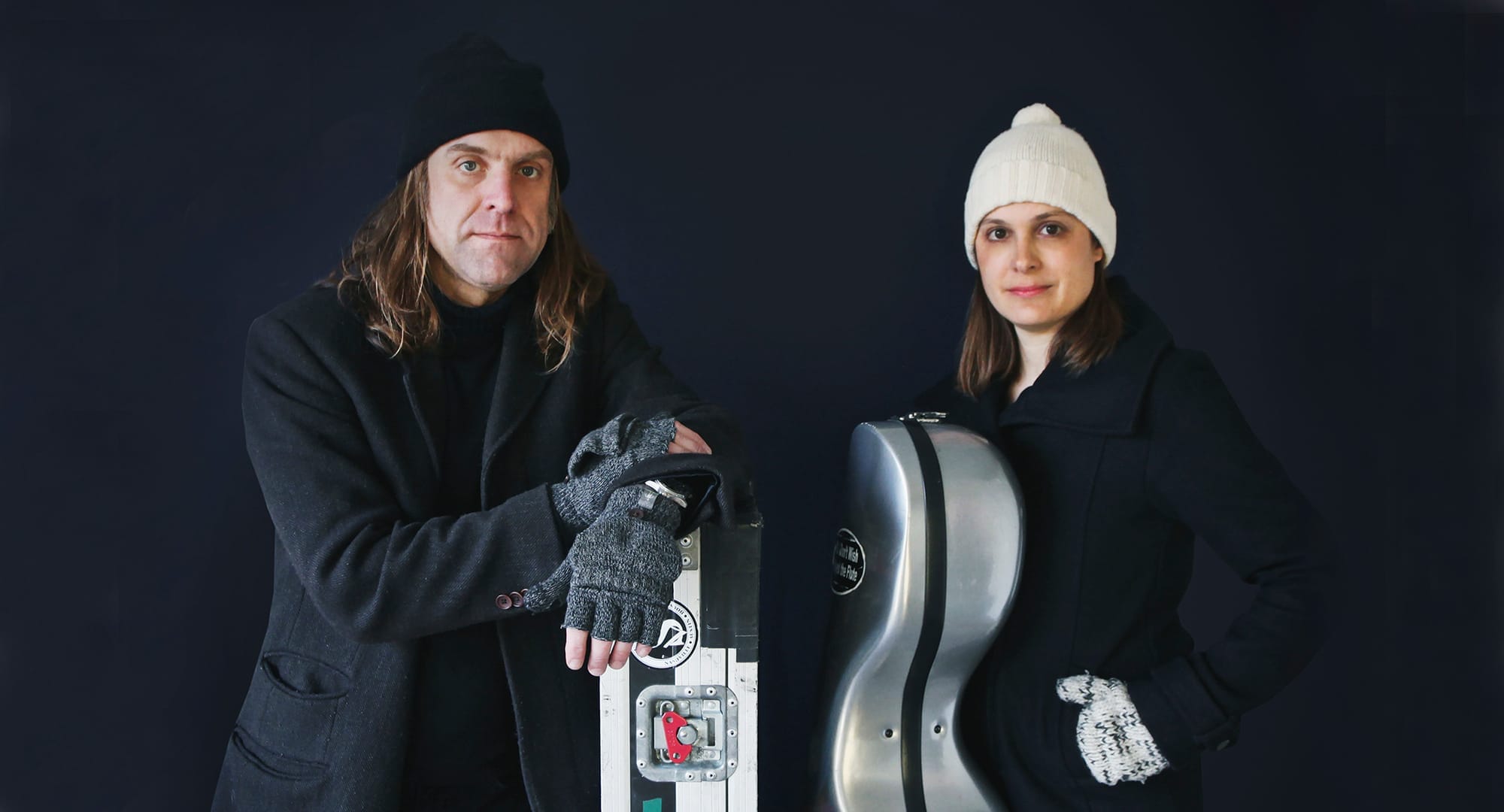 a male and female musician face the camera