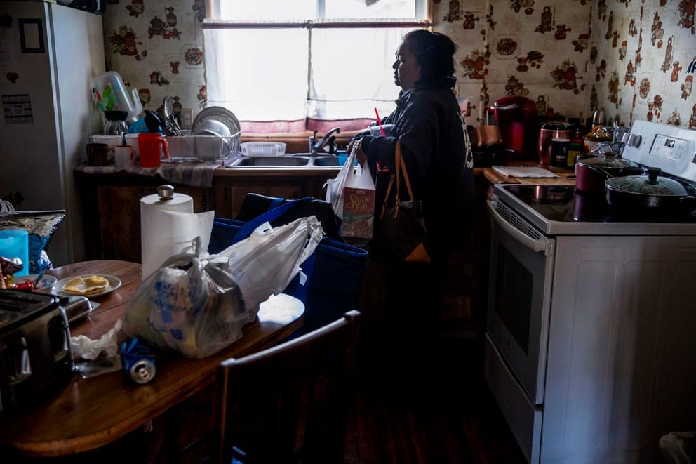 Dawn putting away grocers in her kitchen