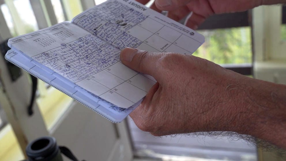 Bill Austin holds his daily calendar booklet