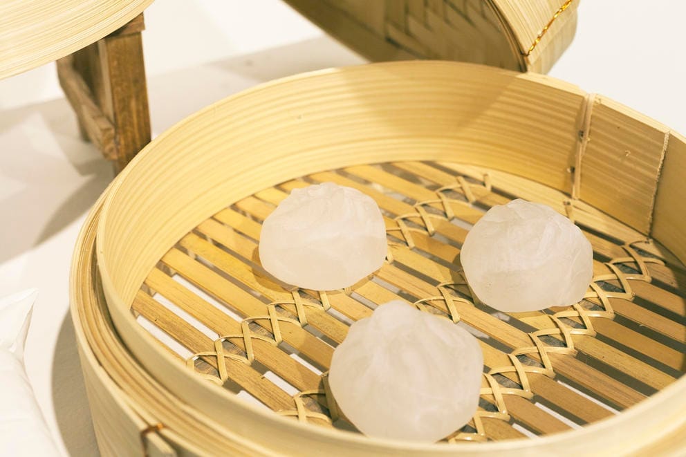 Dumplings made from glass sitting in a bamboo steamer