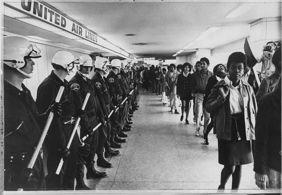 A depth-of-field photo of protesters and officers parallel to eachother