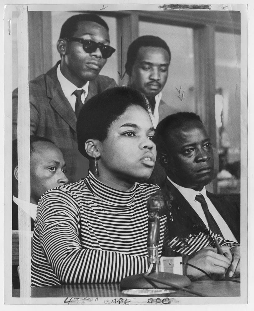 Infanta Spence sits infront of mic