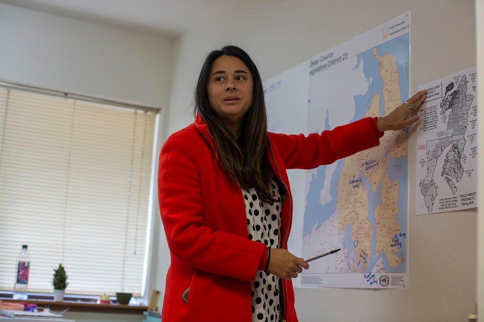 Erin Phillips points at a map of precincts on a wall