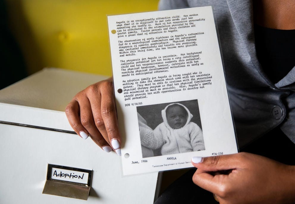 Angela Tucker holding adoption notice