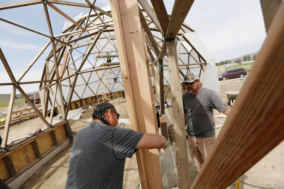 workers install a door in the dome.