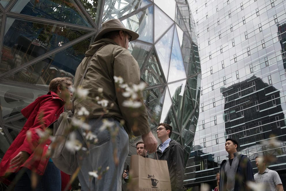 People walk past the Amazon spheres
