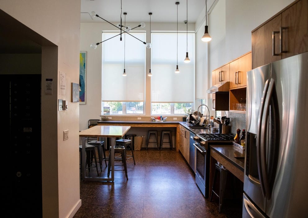 View of a kitchen with tables and a fridge