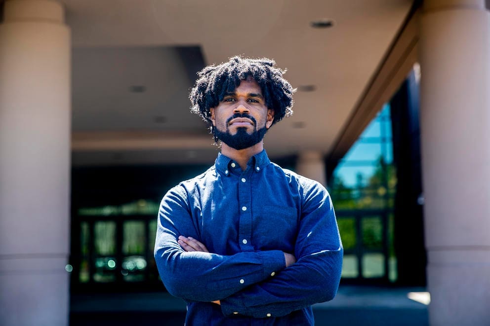 State Rep. Jesse Johnson stands with his arms folded across his chest
