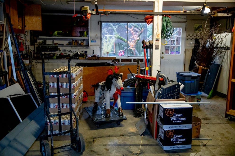 A decorated toy horse and cases of beer in a garage