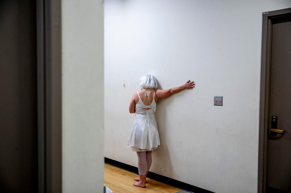 Cardiff stretches her arms on a wall