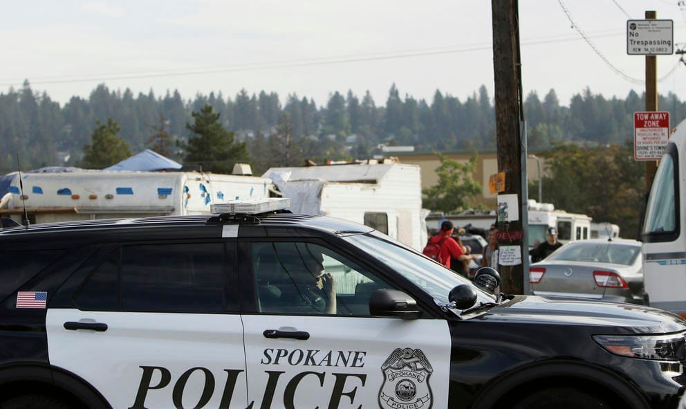 A police vehicle drives by the Camp Hope encampment