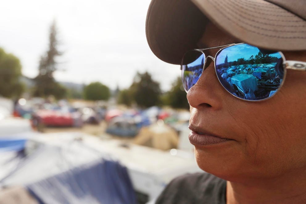 Camp Hope encampment reflected in a woman's sunglasses