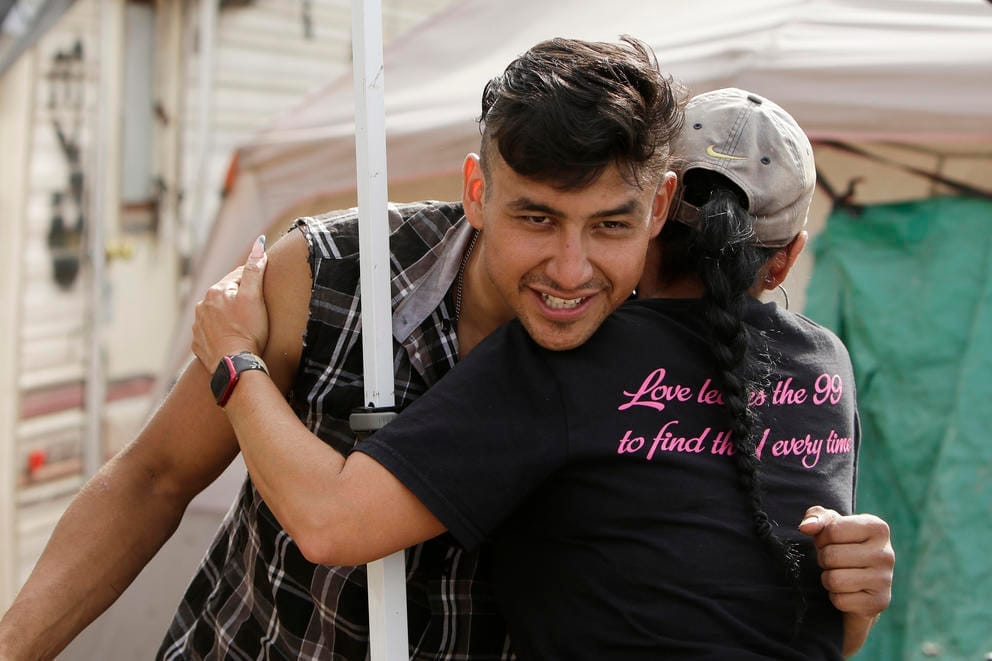 A man hugging a woman at the Camp Hope encampment