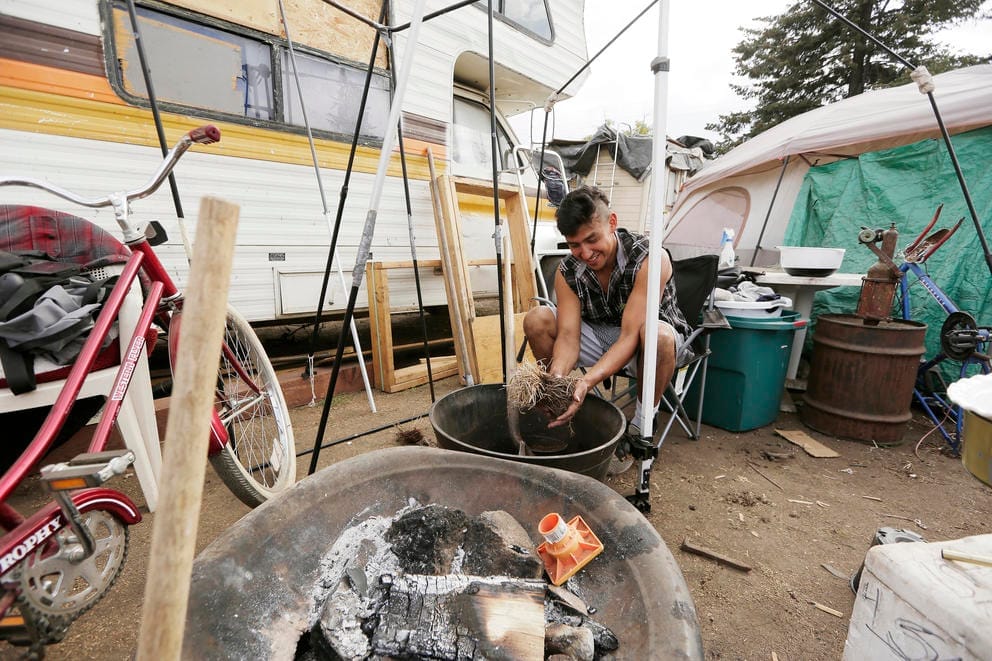 A man making compost at the Camp Hope encampment