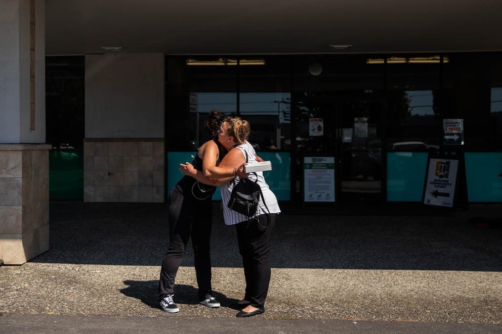 two women hugging outside the court