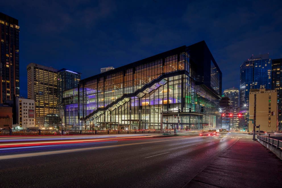 Night-time photo of the convention center building, lights from cars become streaking lights in the dark